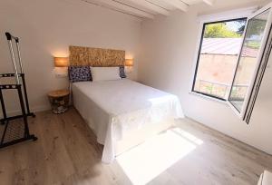 a bedroom with a white bed and a window at Aldea de Rosalía in Padrón