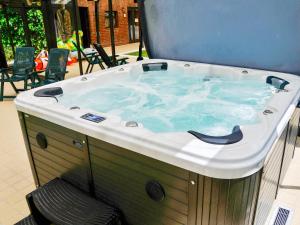 a jacuzzi tub in a room with chairs at Field House in Baschurch