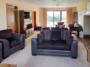 a living room with a couch and two chairs at Field House in Baschurch