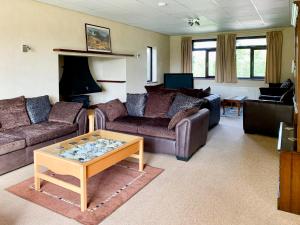 a living room with couches and a coffee table at Field House in Baschurch
