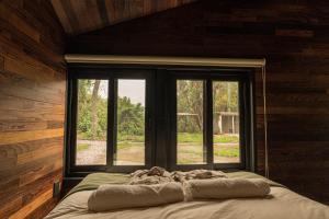 a bed in a room with a window at Rosalia Haras Glamping - Experiencia ecuestre in Atlixco