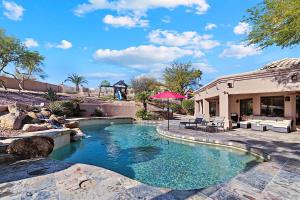 ein Swimmingpool in einem Garten mit einem Haus in der Unterkunft Hillside Tranquility in Fountain Hills