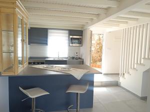 a kitchen with a counter and two stools in it at Aldea de Rosalía in Padrón
