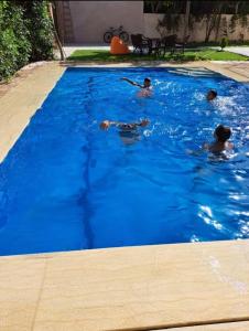 a group of people swimming in a swimming pool at فيلا تسنيم للعائلات in Naj‘ al Aḩwāl