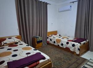 a bedroom with two beds and a window at فيلا تسنيم للعائلات in Naj‘ al Aḩwāl