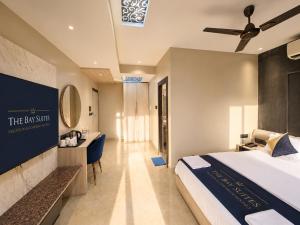 a hotel room with a bed and a desk at The Bay Suites - NIS in kolkata +50 photos