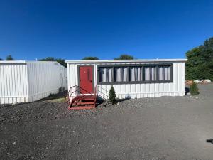 a white garage with a red door and a fence at House # 9 in Las Vegas