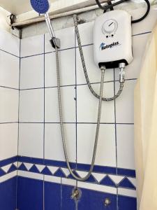 a shower in a bathroom with blue and white tiles at El Duke Kahanamoku surf hostel in Pacasmayo
