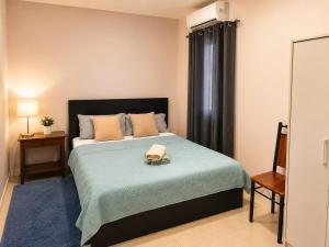 a bedroom with a large bed with a blue blanket at DOLFIJN STUDIOS Comfortable 1BR Apartment Fast WiFi AC North Paramaribo in Paramaribo