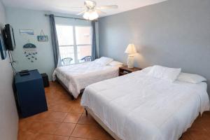 a hotel room with two beds and a window at EZ Beach Access Great Family Condo SpaceX view in South Padre Island