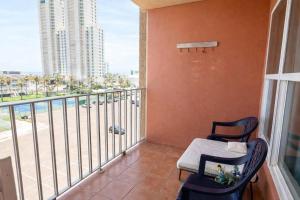 a balcony with a chair and a view of a city at EZ Beach Access Great Family Condo SpaceX view in South Padre Island