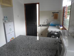 a kitchen with a counter top and a refrigerator at Anse Norwa Self Catering in Mahe