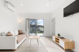a living room with a couch and a table at Modern 1 Bed Apartment - 6 Min Walk to Beach in Callala Beach +13 photos