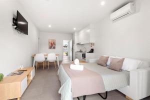 a living room with a bed and a kitchen at Modern 1 Bed Apartment - 6 Min Walk to Beach in Callala Beach