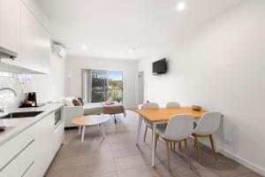 a kitchen and dining room with a table and chairs at Modern 1 Bed Apartment - 6 Min Walk to Beach in Callala Beach