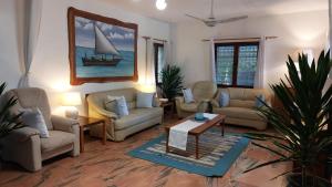 a living room with couches and a boat on the wall at Nyali Garden Escape Villa in Mombasa