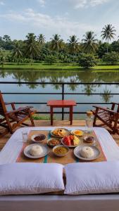 a tray of food on a table with a view of a lake at Lake Cabana in Udawalawe