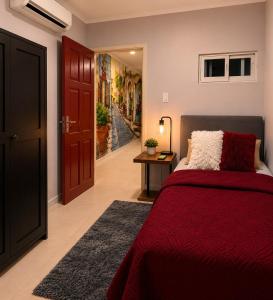 a bedroom with a red bed and a hallway at DOLFIJN STUDIOS Stylish 2BR Apartment Fast WiFi AC Near Center in Paramaribo