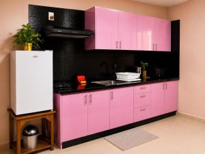 una cucina rosa con lavello e frigorifero di Spacious 1-BR Studio with Fast WIFI l Work-Friendly Stay a Paramaribo