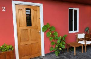 una casa rossa con una porta di legno e una pianta di Spacious 1-BR Studio with Fast WIFI l Work-Friendly Stay a Paramaribo