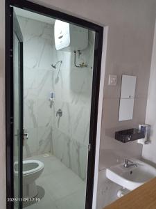 a bathroom with a shower and a toilet and a sink at Menepi Bali in Uluwatu +12 photos