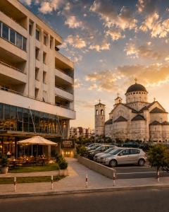 a parking lot with cars parked in front of a building at Urban Temple Apartment near Cathedral Free Parking in Podgorica