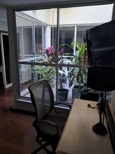 an office with a desk and a chair in front of a window at Ana Ines in Santiago del Estero