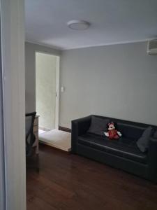 a black couch in a living room with a stuffed animal at Ana Ines in Santiago del Estero