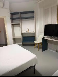 a bedroom with a bed and a desk with a computer at La voglia albergo in Villanova sullʼArda