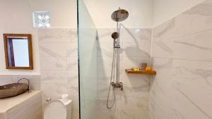 a shower with a glass door in a bathroom at ANANDA Bingin Guesthouse in Bingin Beach +33 photos