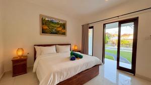 a bedroom with a bed with a stuffed elephant on it at ANANDA Bingin Guesthouse in Bingin Beach