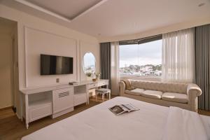 a hotel room with a bed and a television at Nature Hotel and Suite in Da Lat