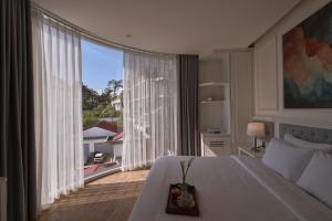 a bedroom with a large bed and a large window at Nature Hotel and Suite in Da Lat +133 photos