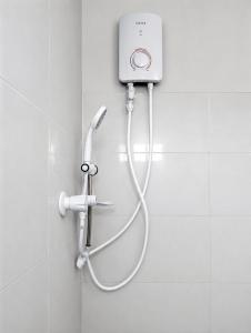 a shower with a hose attached to a wall at The Blue Sapphire Of Wilpattu in Wilpattu