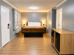 a hotel room with a bed and a desk at Mark Twain Motor Inn in Elmira