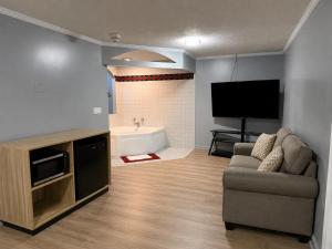 a living room with a couch and a flat screen tv at Mark Twain Motor Inn in Elmira