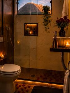 a bathroom with a shower with a toilet and candles at Aconchego Valença & Spa in Nova Friburgo
