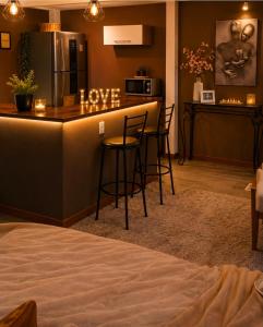a kitchen with a bar with stools in a room at Aconchego Valença & Spa in Nova Friburgo