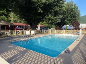 a large blue swimming pool next to a fence at Travelowes Motel - Maggie Valley in Maggie Valley