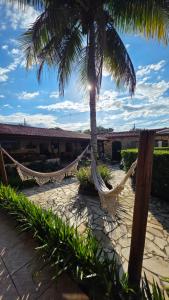 a resort with hammocks and palm trees on a patio at Pousada das Saíras in Paraty