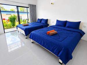 two beds in a room with blue sheets at Blue Zone Hostel in Kaôh Rŭng (3)