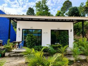 a small white house with a roof at Blue Zone Hostel in Kaôh Rŭng (3)