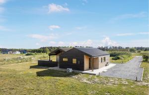 a small house with a black roof on a field at Stunning Home In Jerup With Sauna in Jerup +20 photos