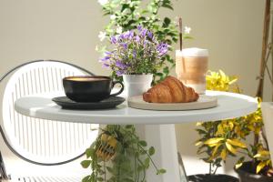 a table with a cup of coffee and a plate of croissants at Hillside Koh Samui in Ban Khlong Mae Nam
