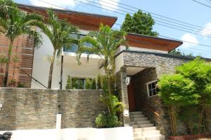 a brick house with palm trees in front of it at Hillside Koh Samui in Ban Khlong Mae Nam