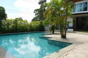 a swimming pool in the middle of a house with palm trees at Hillside Koh Samui in Ban Khlong Mae Nam