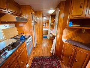 a kitchen with wooden cabinets and a stove top oven at Tiny house móvel com vista 360 in São Roque