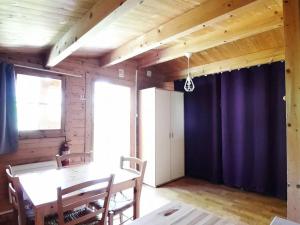 a dining room with a table and a purple curtain at Chalet - Animaux admis - 4 pers. - API-1-52-2942 in Annot