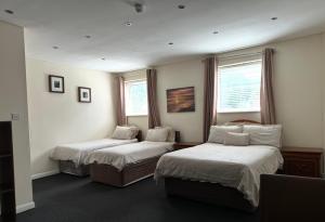 a hotel room with two beds and two windows at The Goodlife Guesthouse in Harwich +33 photos