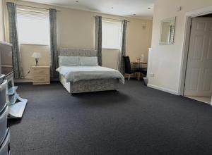 a bedroom with a bed and a desk with a desk at The Goodlife Guesthouse in Harwich